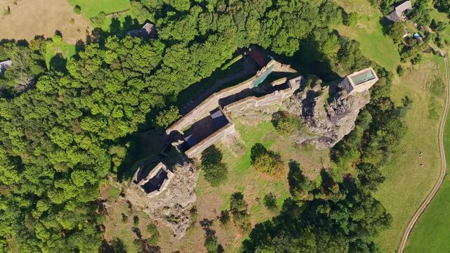 Aerial view of Trosky Castle amidst lush green forest and ancient rock formations, Troskovice, Czech Republic.