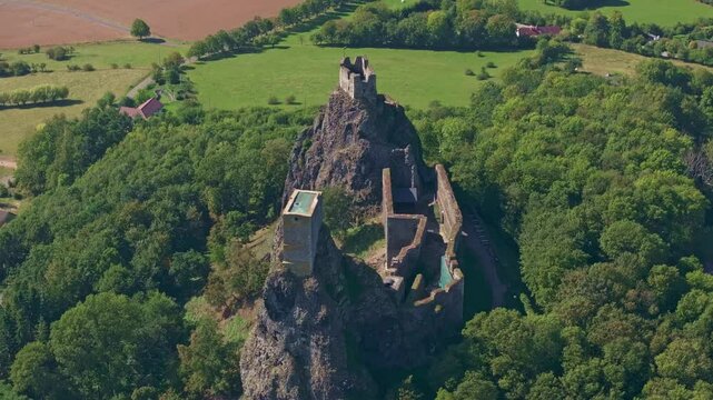Aerial view of Trosky Castle surrounded by lush greenery and scenic rock formations, Troskovice, Czech Republic.