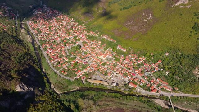 Aerial view of picturesque village along the Vit River surrounded by tranquil countryside and historic architecture, Glozhene, Bulgaria.