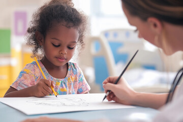Child engaged in creative drawing activity with an instructor in a bright classroom setting during the afternoon
