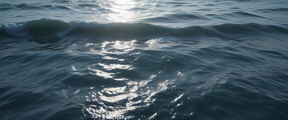 Fototapeta premium Ocean water with a subtle shimmering effect of light dancing across the waves in shades of blue and silver, blue, silver, abstract