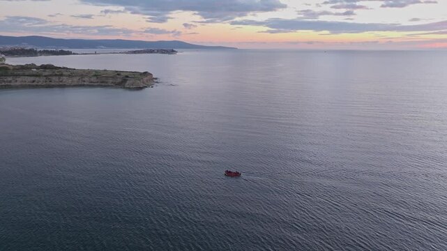 Aerial view of the tranquil Black Sea at sunrise with fishing boats and a picturesque coastline, Nesebar, Bulgaria.