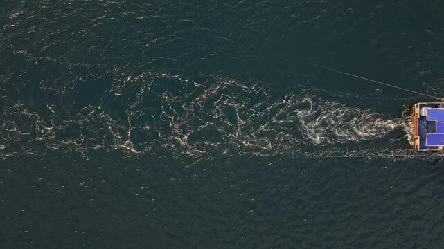 Aerial view of fishing vessel on calm waters during sunrise over the Black Sea, Nesebar, Bulgaria.