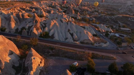Goreme, Turkey - 01 December 2024: Aerial view of hot air balloons over love valley at sunrise with unique rock formations, Goreme, Turkey.