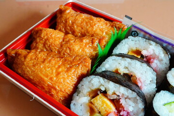 いなり寿司と太巻きと細巻きが入った美味しいお弁当。駅で購入した駅弁当。