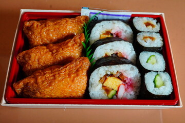いなり寿司と太巻きと細巻きが入った美味しいお弁当。駅で購入した駅弁当。