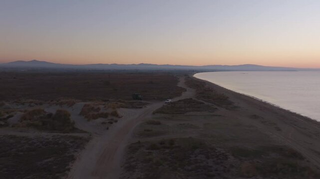 Aerial view of serene Aegean Sea at sunrise with beautiful coastline and tranquil beach, Epanomi, Greece.