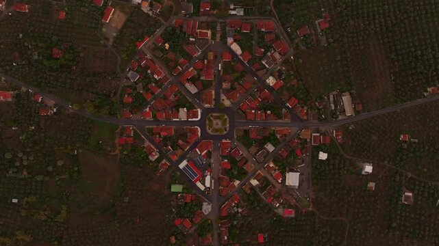 Aerial view of a beautiful village with olive groves and streets at sunset over the Ionian Sea, Nea Koroni, Greece.