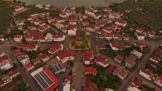Aerial view of a beautiful village with red roofs and historic architecture at sunset over the Ionian Sea, Nea Koroni, Greece.