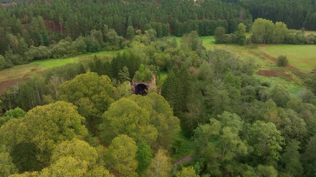 Aerial view of the ruins of St. Jana Krtitele church surrounded by beautiful autumn foliage in a tranquil forest, Kocov, Czech Republic.