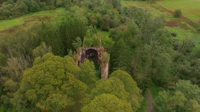 Aerial view of the ruins of St. Jana Krtitele church surrounded by lush green forest, Kocov, Czech Republic.