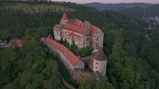 Aerial view of pernstejn castle at sunset surrounded by forest and hills, nedvedice, czech republic.