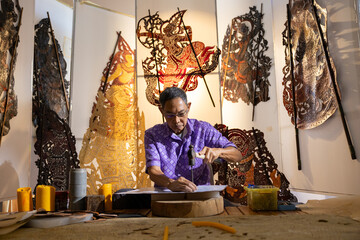 Craftsmen create traditional Thai Khon puppets.