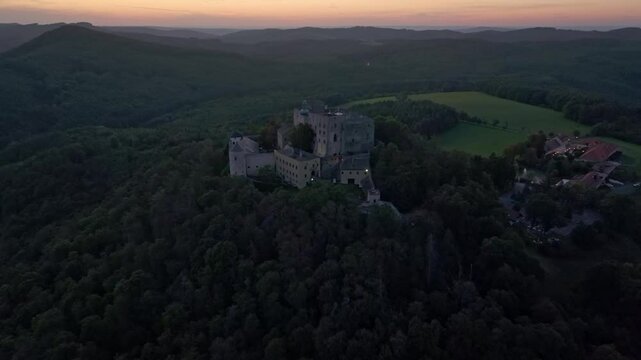 Aerial view of Buchlov Castle at sunset surrounded by tranquil hills and lush forest, Buchlovice, Czech Republic.