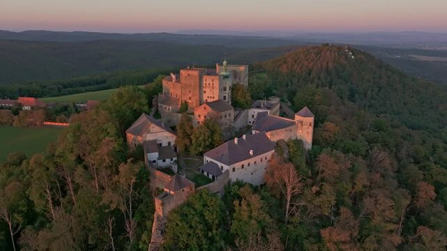 Aerial view of buchlov castle at sunset surrounded by forested hills, buchlovice, czech republic.