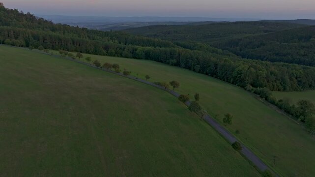 Aerial view of Buchlov Castle at sunset surrounded by tranquil rolling hills and lush forests, Buchlovice, Czech Republic.