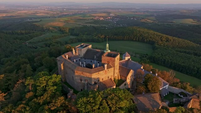 Aerial view of Buchlov Castle at sunset surrounded by a beautiful forest and scenic countryside, Buchlovice, Czech Republic.