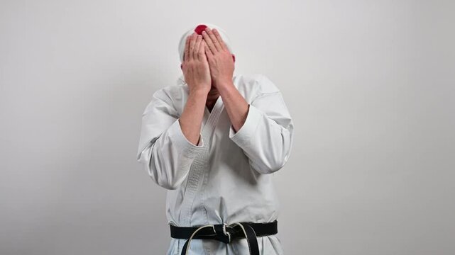 Black belt karate master covering his face