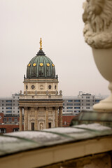 Rooftop view of the New German Cathedral golden adorned Dome in Berlin from the French Church terrace, showing contrast between historical and modern  architecture, Foggy cloudy day. Copy space
