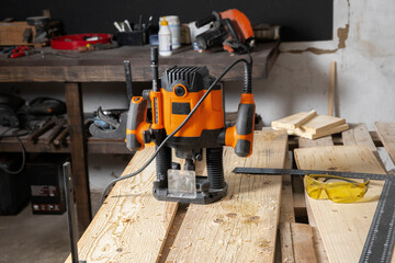 A hand router on a table in a carpentry workshop.