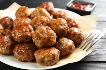 Many delicious meatballs on dark wooden table, closeup