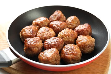 Tasty meatballs in frying pan on white table, closeup