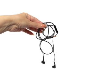 Female hand holding black wired headphones isolated on white background. Modern gadgets for communication