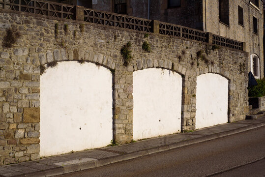 Arco de muro de piedra tapiado con yeso