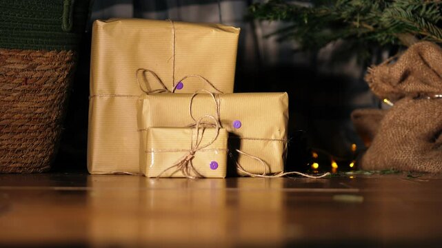 Gift wrapped in brown paper and string with Christmas lights bokeh background