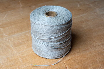 spool of twine rope on wooden table