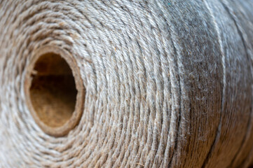 spool of twine rope on wooden table, close up