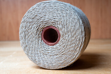 spool of twine rope on wooden table, close up