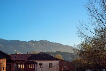 Sierra del Sueve tras tejados de casas de Colunga en Asturias © Darío Peña