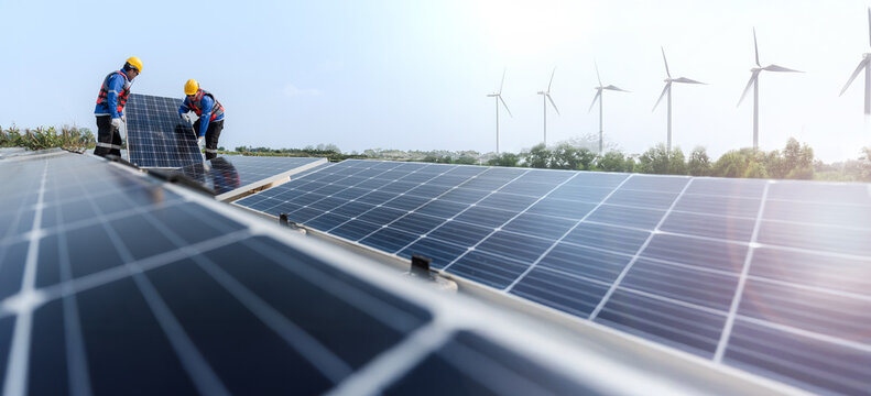 Male workers repair Floating solar panels on water lake. Engineers construct on site Floating solar panels at sun light. clean energy for future living. with wind turbine farm for renewable energy.