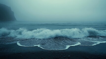 Fototapeta premium Moody Coastal Scene Dramatic Ocean Waves Crashing on Dark Sand Beach in Fog