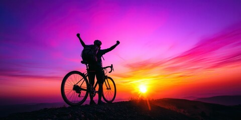 Obraz premium Silhouette of a male cyclist celebrating against a vibrant sunset backdrop.