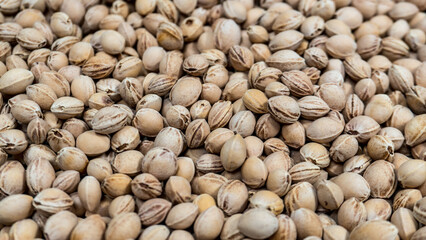 A dense layer of kernels fills the frame. Oval shapes with visible ridges. Light brown tones dominate. Textures and patterns are clearly visible. The image shows natural, raw materials