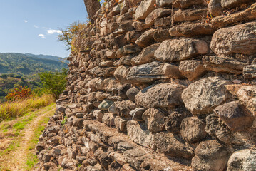 Architectural remains in Mixco Viejo, an ancient Mayan city, testimony of a great civilization, in the middle of green forests, ravines, under a blue sky.