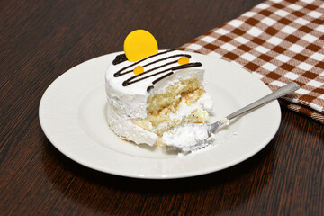 a cake with cream isolated on the white saucer and checkered towel