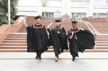 Diverse international students with diplomas at university campus