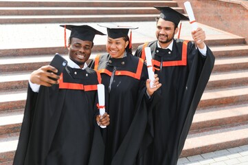 Diverse international students with diplomas at university campus