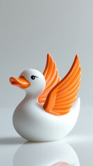 White rubber duck with orange wings spreading on reflective surface