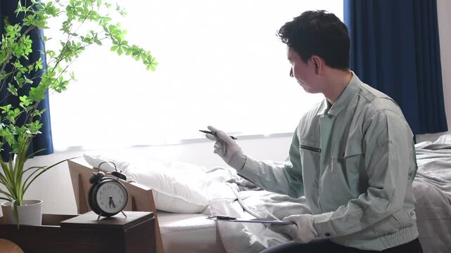 ベッドを確認するアジア人の作業員男性