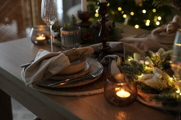 Christmas place setting with festive decor on wooden table in room