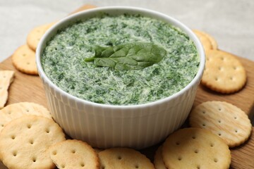 Delicious spinach sauce served with crackers on grey table, closeup