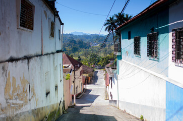 View of the colonial architecture, streets, avenues and monuments of the city of Cobán. People walk around on an everyday day.