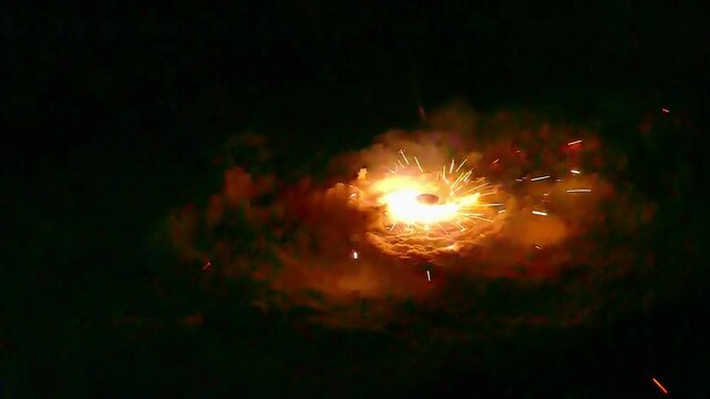 Spinning fireworks on the ground with white sparks