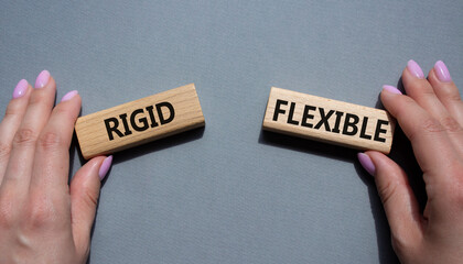Rigid or Flexible symbol. Concept word Rigid or Flexible on wooden blocks. Businessman hand. Beautiful grey background. Business and Rigid or Flexible concept. Copy space