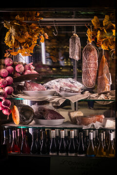 Italy - 06 February 2023: View of gourmet charcuterie display with wine bottles and autumn leaves, Tuscany, Italy.