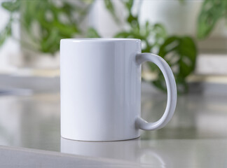 White coffee mug on grey kitchen table against green plant closeup, mockup